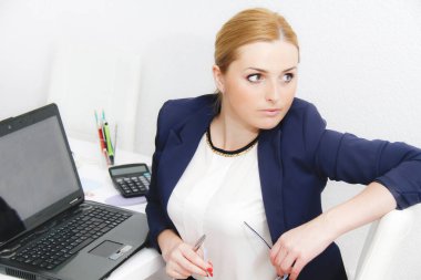 Yatırım çizelgelerini hesap makinesiyle analiz eden bir iş kadını.