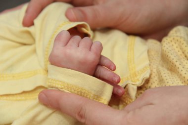 Annem ve onun yeni doğan bebek, yeni doğan el ele tutuşarak üst