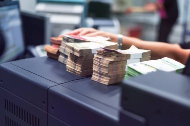 Banka çalışanları banka kasasında para sayıyor ve sıralıyor. Lar