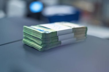 Banka çalışanları banka kasasında para sıralayıp sayıyor.
