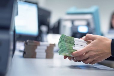Banka çalışanları banka kasasında para sayıyor ve sıralıyor. Lar