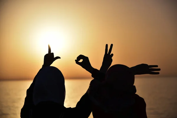 Twee jonge moslim vrouw tonen woord van liefde getoond door handen durin — Stockfoto