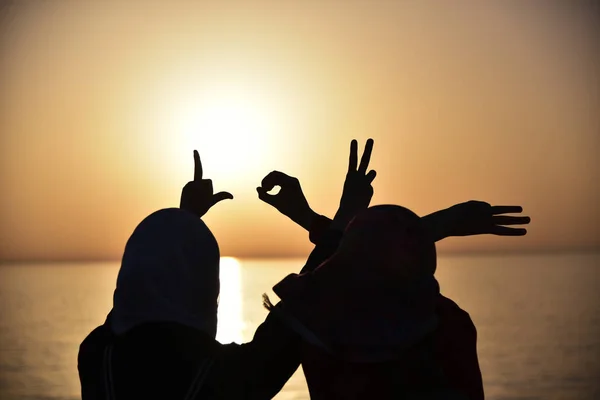 Twee jonge moslim vrouw tonen woord van liefde getoond door handen durin — Stockfoto