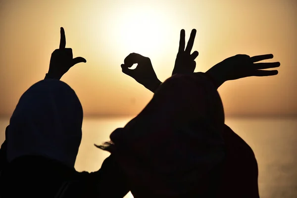 Dos jóvenes musulmanas mostrando palabra de amor mostrada por manos durin — Foto de Stock
