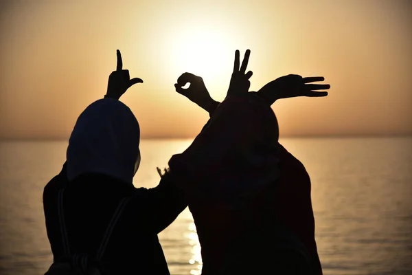 Duas jovens muçulmano mulher mostrando palavra de amor mostrado por mãos durin — Fotografia de Stock