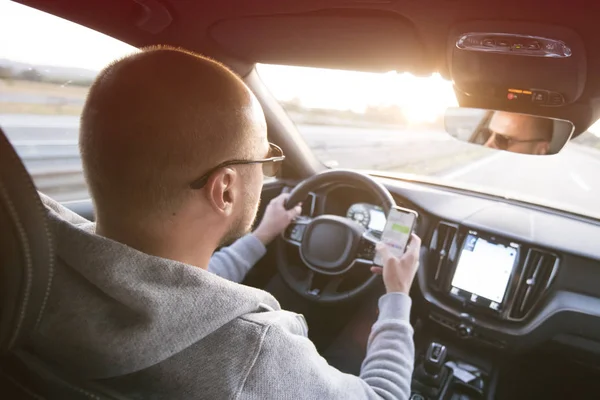 Uomo guida auto utilizzando il messaggio di sms del telefono cellulare o chiamando — Foto Stock