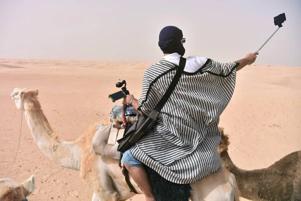 Bédouin en vêtements traditionnels chevauchant chameau dans le désert du sahara, Tu — Photo