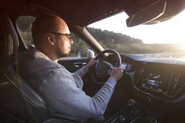 Araba süren bir adam. Başarı devrede. Yakışıklı genç adam araba kullanıyor.