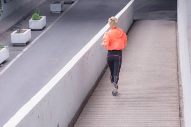 Koşan kadın. Şehirde kadın fitness modeli eğitimi var..