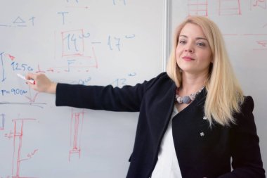 Güzel genç bayan öğretmen ders sırasında bir öğrenciye yardım ediyor. F