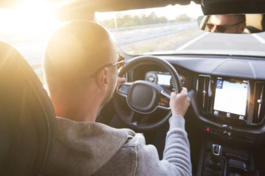 Araba süren bir adam. Başarı devrede. Yakışıklı genç adam araba kullanıyor.