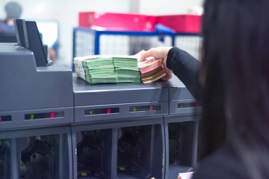 Banka çalışanları banka kasasında para sayıyor ve sıralıyor. Lar