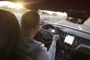 Araba süren bir adam. Başarı devrede. Yakışıklı genç adam araba kullanıyor.