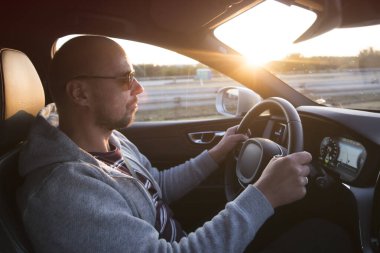 Araba süren bir adam. Başarı devrede. Yakışıklı genç adam araba kullanıyor.