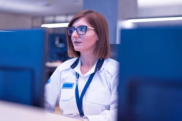Guardia di sicurezza femminile che lavora sui computer mentre seduto nel — Foto Stock