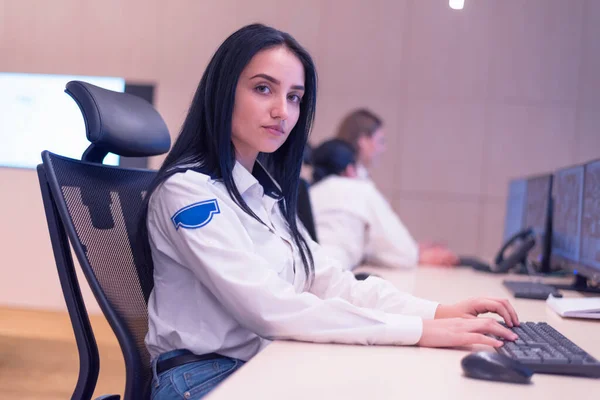 Женщина-охранник работает за компьютерами, сидя в — стоковое фото