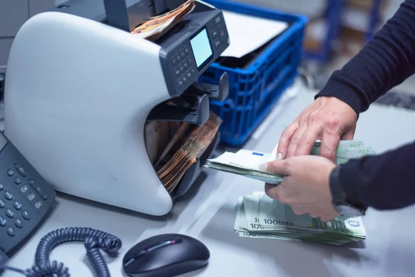 Banka çalışanları banka kasasında para sayıyor ve sıralıyor. Lar