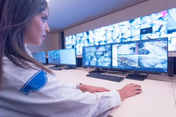 Guarda de segurança do sexo feminino trabalhando em computadores enquanto sentado no — Fotografia de Stock