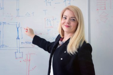 Güzel genç bayan öğretmen ders sırasında bir öğrenciye yardım ediyor. F