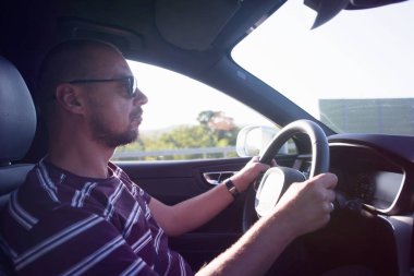 Araba süren bir adam. Başarı devrede. Yakışıklı genç adam araba kullanıyor.