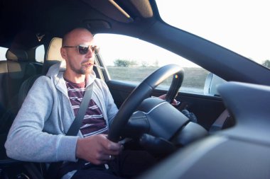 Araba süren bir adam. Başarı devrede. Yakışıklı genç adam araba kullanıyor.