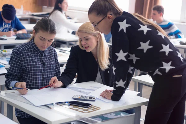 Schöne junge Lehrerin hilft einem Schüler während des Unterrichts. F — Stockfoto