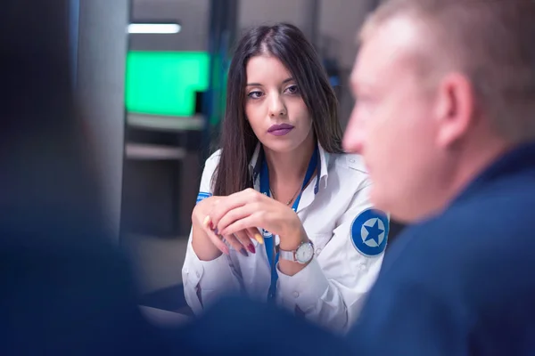 Gruppo di guardie di sicurezza che lavorano sui computer mentre sono seduti in t — Foto Stock