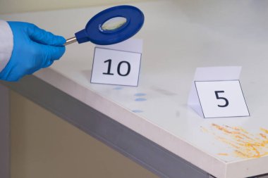 Adli teknisyenler karyolalı kan lekesinden DNA örneği alıyorlar.