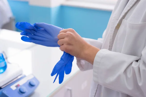 Científica joven del laboratorio que usa guantes para trabajar en —  Fotos de Stock