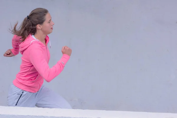 Mujer joven corriendo al aire libre en la carretera urbana. Mujer joven —  Fotos de Stock