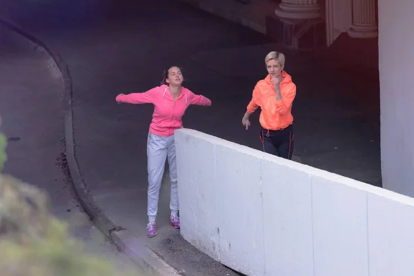 Két egészséges, fiatal, sportos nő, akik felkészülnek a futásra. — Stock Fotó