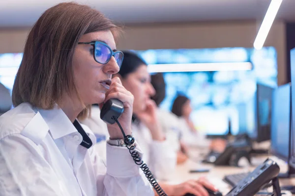 Kadın güvenlik operatörü telefonda konuşuyor, arıyor. 