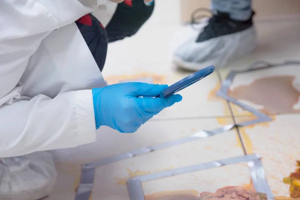 Techniciens médico-légaux prélever un échantillon d'ADN de la tache de sang avec lit bébé — Photo