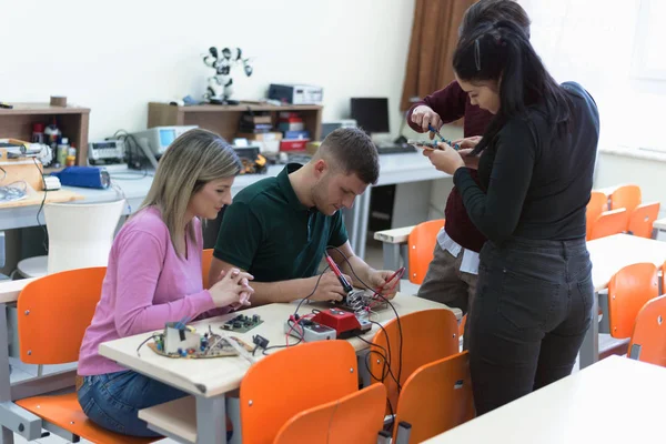 Grupo de jóvenes ingenieros trabajando en el proyecto de robótica. Científico — Foto de Stock