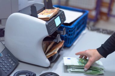 Banka çalışanları banka kasasında para sayıyor ve sıralıyor. Lar