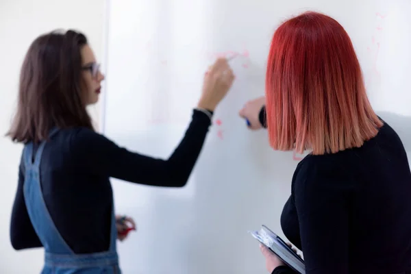 Due giovani studentesse di economia femminile analizzano il finanziamento annuale dell'azienda — Foto Stock