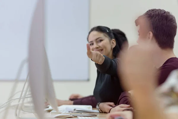 Щаслива студентка-жінка показує великі пальці вгору, посміхаючись різноманітним молодим фантастом — стокове фото