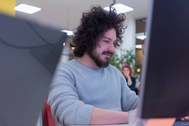 Genç erkek web geliştiricisi güneşli, parlak ofis içinde iş planıyla ilgili beyin fırtınası yapıyor..