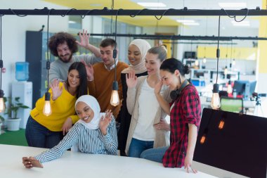 Çok ırklı genç iş adamlarından oluşan bir grup yeni projelerinin ardından selfie çekiyorlar..