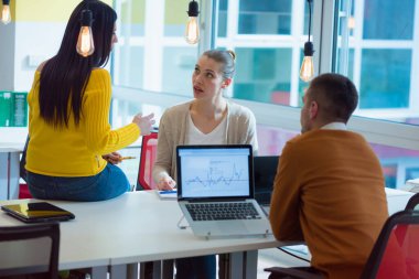 Bir grup genç iş adamı, güneşli, aydınlık ofis içlerinde iş planlarını tartışıyor ve beyin fırtınası yapıyorlar..