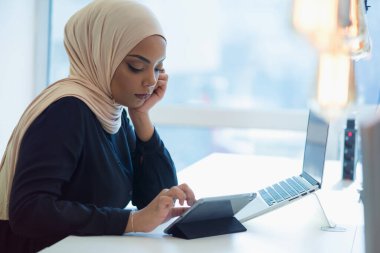 Genç Müslüman Afrikalı Amerikalı iş kadını lider olarak iş başında. Takım çalışması ve çok ırklı kavram. Ekibi arka plandayken başarılı bir iş adamı pozu verdi..