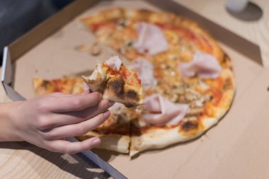 Güzel bir kadın pizza yiyip kola içerken gecenin geç saatlerinde Expres restoranında oturuyor..
