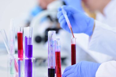 Laboratuvarda test tüpleri, mikroskop, test veya araştırma ile çalışan genç erkek laboratuvar bilim adamı. Bilim, kimya, biyoloji, tıp ve insan konsepti..