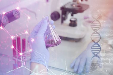 Laboratuvarda test tüpleri ve mikroskop ile çalışan iki genç laboratuvar bilim adamı klinik laboratuarında test veya araştırma yapıyor. Bilim, kimya, biyoloji, tıp ve insan konsepti.