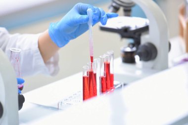 Laboratuvarda mikroskopla araştırma, mikrobiyolojik analiz ve tıp yapan genç bir kadın bilim adamı..