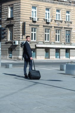 Ofis dışındaki genç iş adamının portresi. Toplantı Konsepti. Adam yürüyor, kahve içiyor, ofise gidiyor..