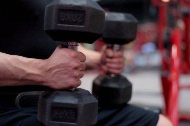 Çekirdek Vücut Geliştirme. Kas geliştiren vücut geliştirici beden eğitimi modeli. Spor salonunda dambılları olan kollar. Spor salonundaki egzersizlerin konsept fotoğrafı