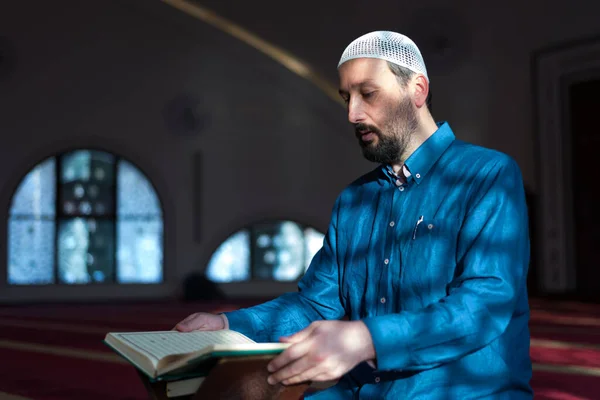 若いアラビア語のムスリム男性はコーランを読んで祈ります モスクの中で聖なるコーランを読む宗教的なイスラム教徒の男 — ストック写真