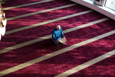 Genç Arap Müslüman adam Kuran okuyup dua ediyor. Camide Kur 'an okuyan dindar Müslüman adam..