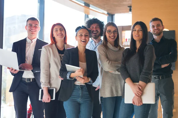 Başarılı yaratıcı iş ekibinin portresi kameraya bakıyor ve gülümsüyor. Başlangıçta çeşitli iş adamları bir arada duruyorlar.